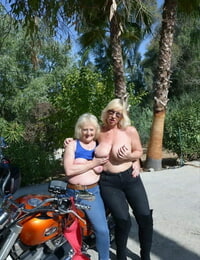 Older blonde lesbians go topless outdoors on a motorcycle