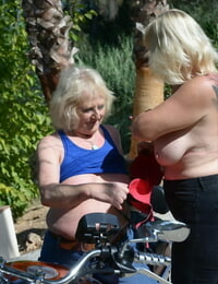Older blonde lesbians go topless outdoors on a motorcycle