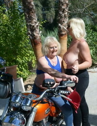ouder Blond lesbische vrouwen ga Topless buiten op een motorfiets