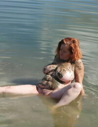 roodharige amateur Misha Heeft betrekking op haar groot tieten in modder terwijl in ondiep Water