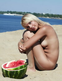 Golden-haired gf Lada poses naked and capture a watermelon on the beach
