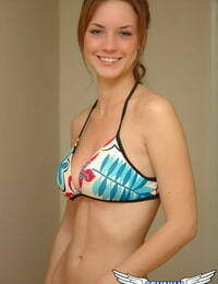 Young solo woman Amy wears a smile while posing non bare in a string bikini