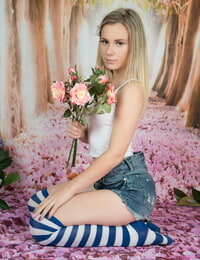 Youthfull looking lady puts down a bunch of flowers before getting totally naked