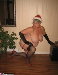Old fledgling Girdle Queen undresses off her attire while wearing a Christmas hat