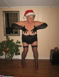 Old fledgling Girdle Queen undresses off her attire while wearing a Christmas hat