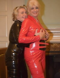 Mature lesbians get together in head-to-toe latex attire on a loveseat