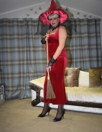 Older ash-blonde liquidates a red velvet dress stance naked in a witchs hat and hosiery