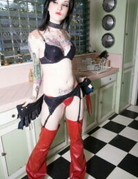 Sexy cosplay lady Melodie poses in crimson chaps & nipple pasties in the kitchen