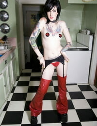 Sexy cosplay lady Melodie poses in crimson chaps & nipple pasties in the kitchen