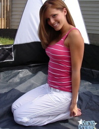 Young redhead Karen glides white trousers over her g-string clothed ass in the backyard