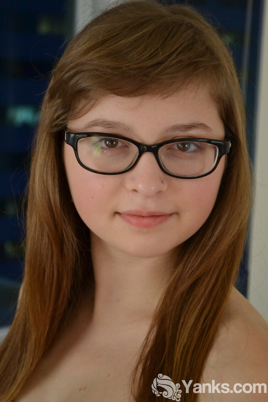 Nerdy teen Lilah Demaray fingers her horny pussy wearing glasses only.