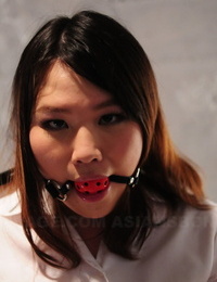 Asian woman Aki Sasahara is fitted with gag in white half-shirt and seized mini-skirt