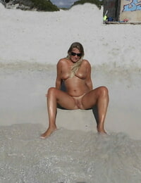 Nackt unerfahrene trägt Sonnenbrille auf sandy Strand und in klar ocean Wasser