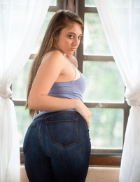 Solo girl in torn jeans demonstrates her phat ass while getting nude