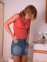 Amateur girl Karen hikes her denim skirt in the bathroom to expose her panties