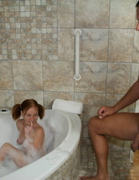 Young looking redhead Alyssa Hart jerks off her stepfather in the bathtub