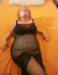 Handcuffs molten granny Caro spreading legs on the bed wearing captured stockings