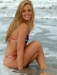 Blonde chick Shannon models in the surf wearing a bikini and a smile