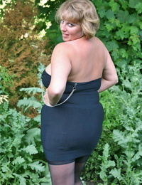 Fat older woman Curvy Claire sets her giant boobs loose in backyard