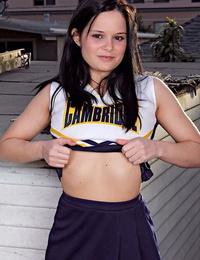 Teenager cheerleader Jenna Ross doffs her uniform to position bare on a rooftop patio