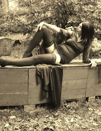 Goth girl Barby Slut bares her big tits and twat atop a casket in the woods