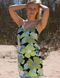 Natural blond teen Oliwia A glides out of a sun dress to posture naked on sand
