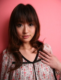 japonês modelo com um Muito rosto stands Vestido contra um cor-de-rosa parede