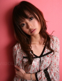 japonês modelo com um Muito rosto stands Vestido contra um cor-de-rosa parede