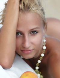 Flexible blonde Afina meditating naked and stretching on the beach