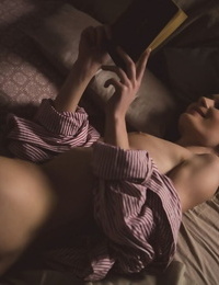Beautiful solo woman reads a book in skimpy light with no clothes on