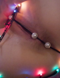 Solo girl Illaria illuminates her smoothly-shaven vag with a cord of Xmas lights