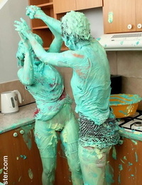 Clothed wailing cover each other in cake mix during a food struggle in kitchen