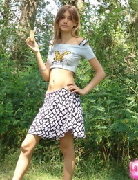 सुडौल युवा किशोर में छोटे टी शर्ट और संक्षिप्त miniskirt प्रस्तुत सड़क पर