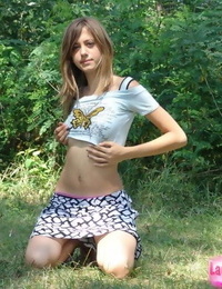 Shapely young teenage in tiny t-shirt and brief miniskirt posing outdoors