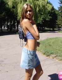 Cute young blond in denim short skirt showcasing off her sexy pierced belly button