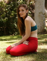 Clad teenage woman Diana Mackie works on her yoga moves in crimson leggings