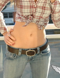 Redheaded country chick models non bare in roped up shirt and denim jeans
