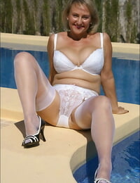 hot und Verführerisch Blonde Reifen Fettsäuren trägt sexy weiß Dessous und Strümpfe in die pool.