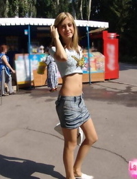 Lean teenager with long legs in brief miniskirt looking sexy in public