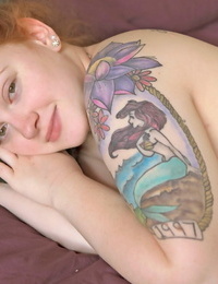 Tattooed redhead with fat floppy knockers boning bare on the bed