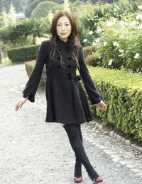 Completely clothed Japanese teenager models in the park in black clothes and stockings