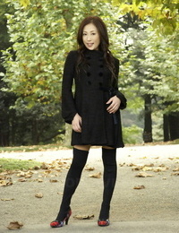 Completely clothed Japanese teenager models in the park in black clothes and stockings
