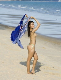 Asian amateur wanders along a beach in just her bikini bottoms